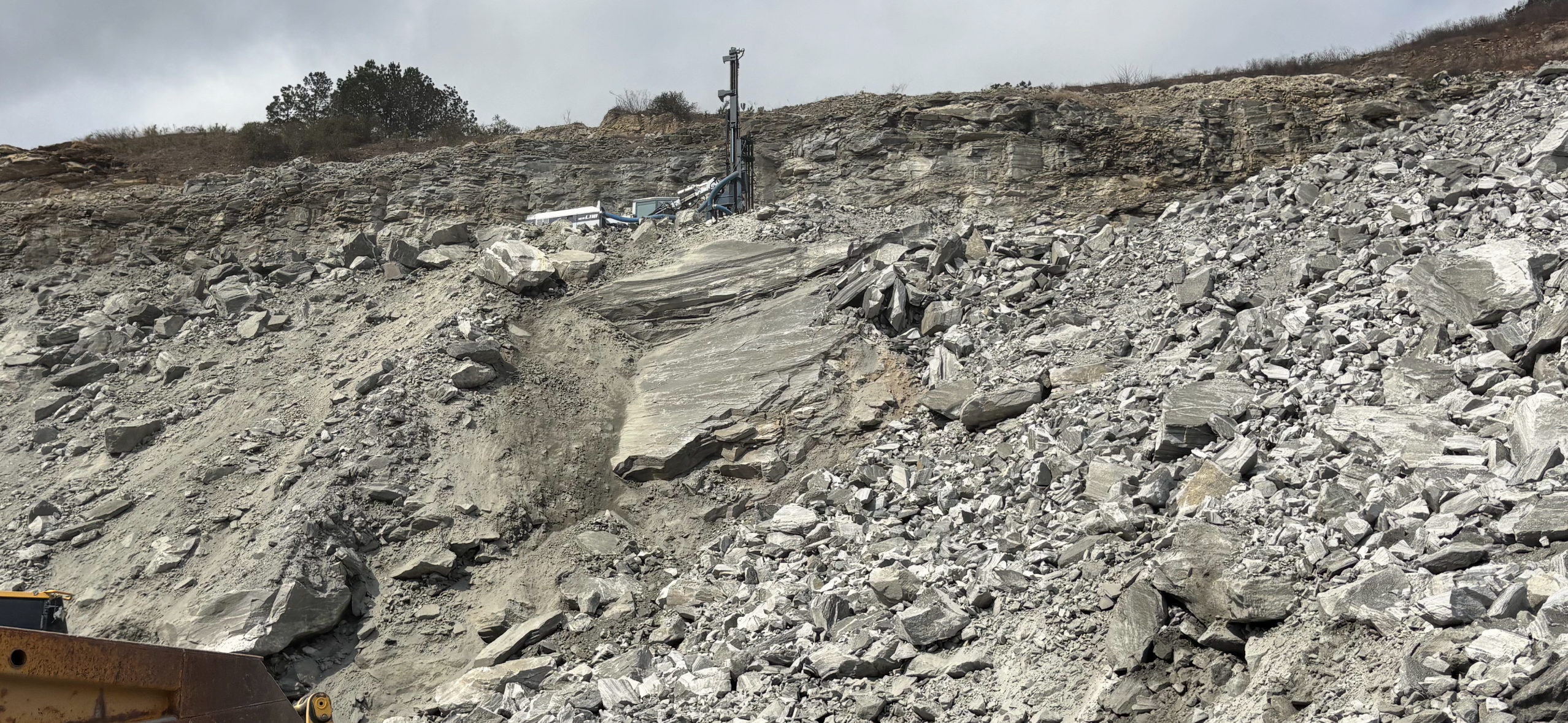 Drill rig working on a quarry rock face